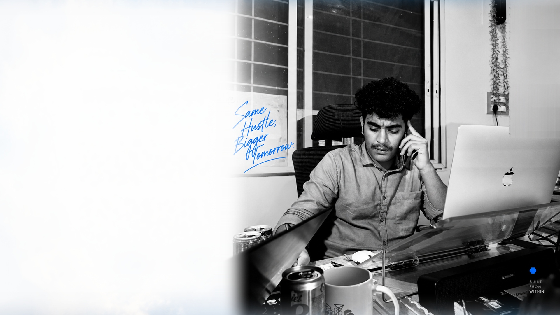HEXNS authentic first office photograph showing founder working late at desk with laptop, phone, and early startup setup